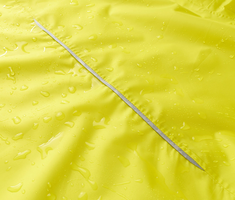 Nahaufnahme einer gelben Regenjacke mit silbernem Reißverschluss und Wassertropfen.