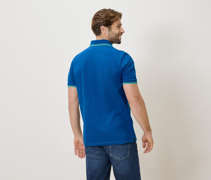 Mann von hinten in blauem Poloshirt und Jeans
