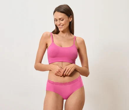 Frau trägt ein pinkes Bralette und Unterwäsche.