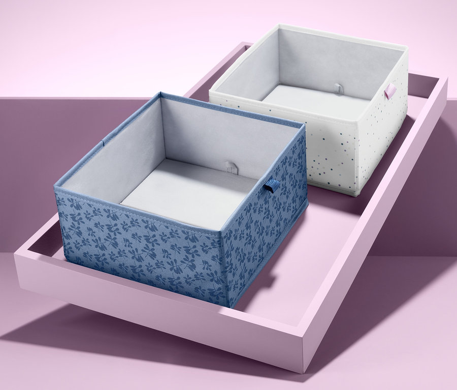 Zwei quadratische Schubladen-Ordnungsboxen auf einem rosa Tablett.