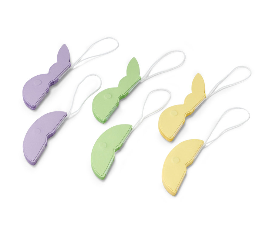 Sechs Papier-Osteranhänger, 6 Papier-Osteranhänger in Lila, Grün und Gelb liegen auf einer weißen Oberfläche.