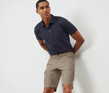 Mann posiert in beigen Funktionsshorts.