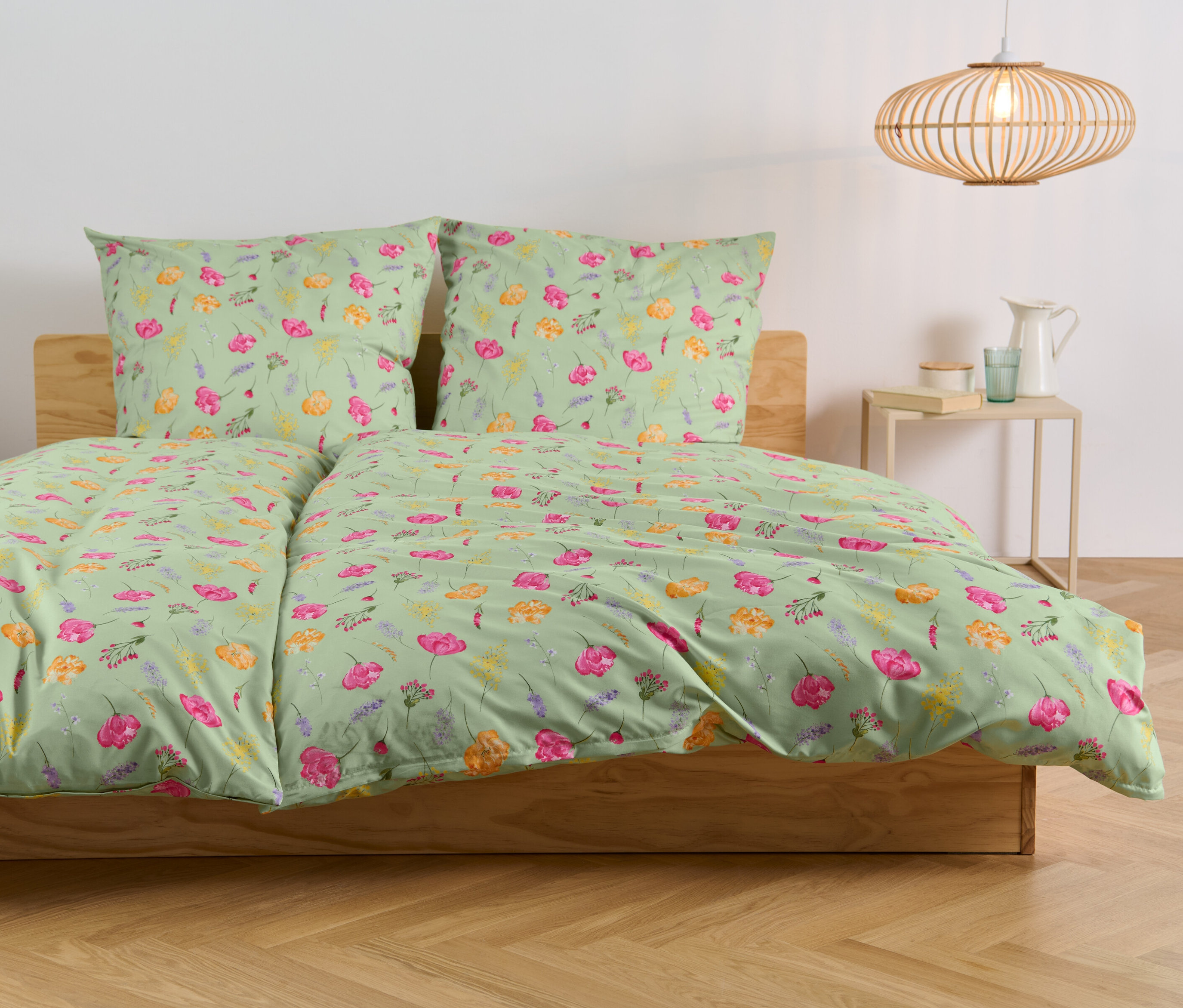 Bett mit Microfaser-Bettwäsche mit Blumenmuster.