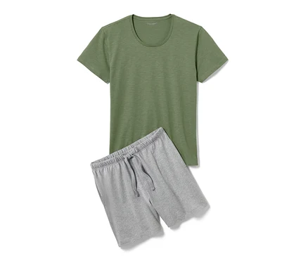 Ein grünes T-Shirt und eine graue Shorty-Pyjama liegen auf einem weißen Hintergrund.
