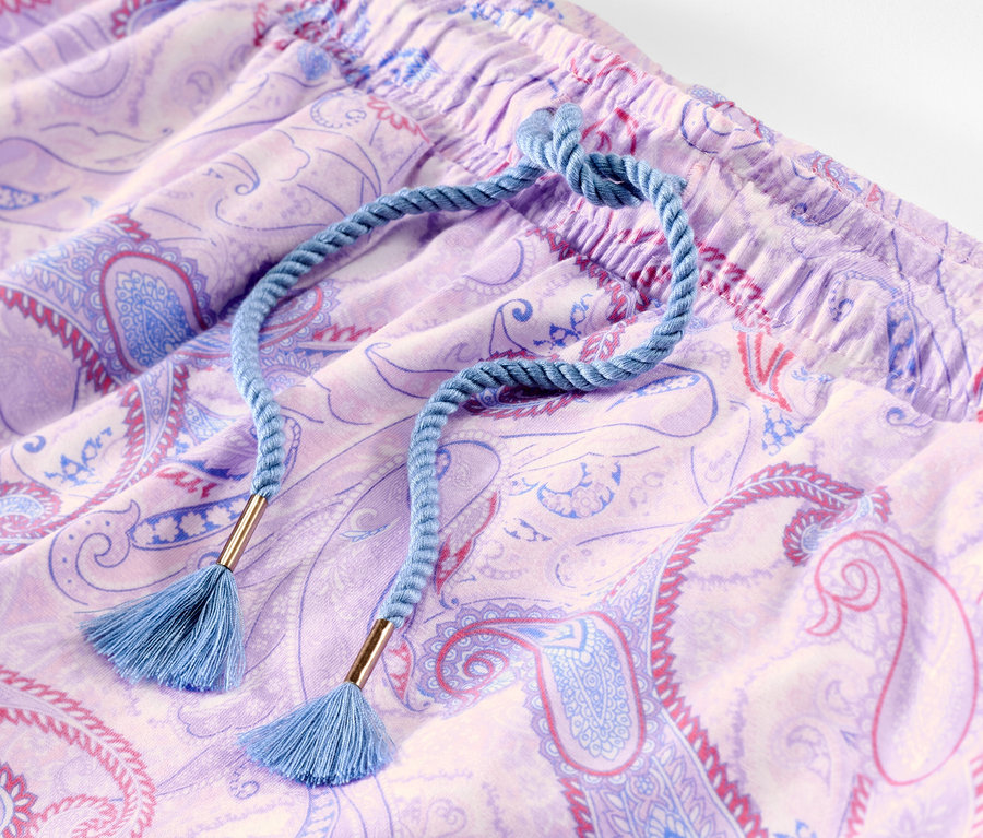 Detailaufnahme einer Pyjamahose mit Paisley-Muster und blauer Kordel.
