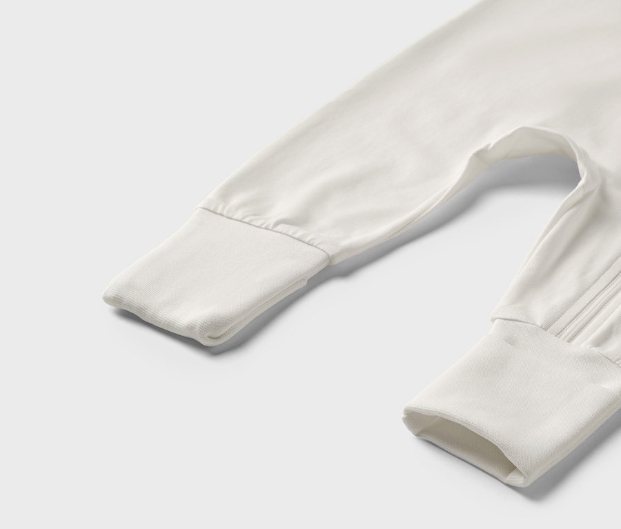 Detailaufnahme eines weißen/grünen Baby-Pyjamas.