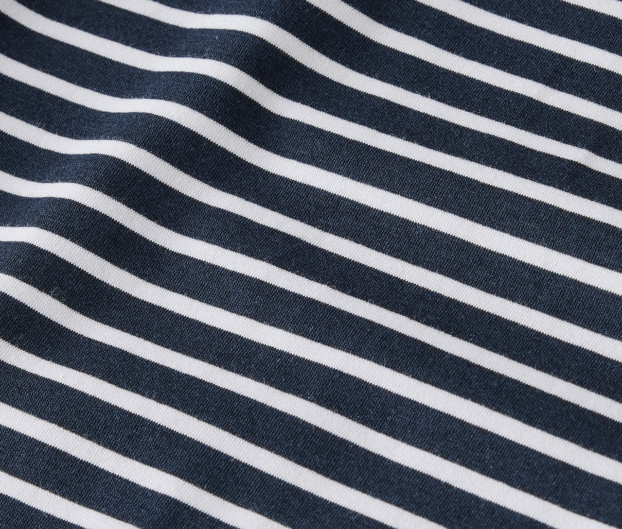Detailaufnahme eines Stoffes mit dunkelblauen und weißen Streifen.