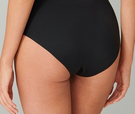 Rückansicht einer Frau, die einen schwarzen Slip trägt.