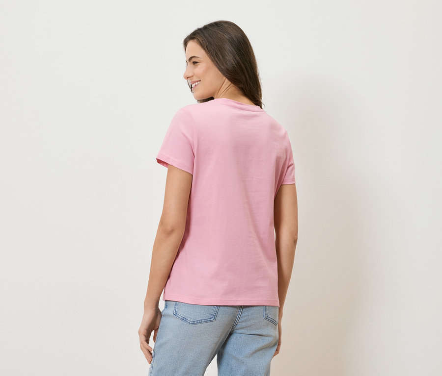 Frau von hinten, mit rosa T-Shirt und hellblauen Jeans.