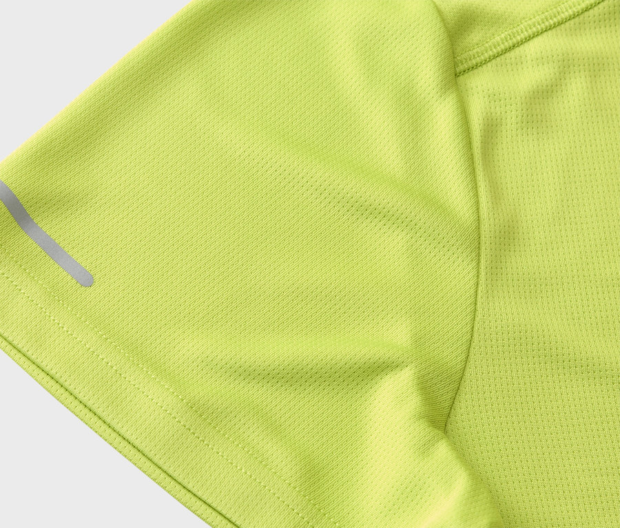 Nahaufnahme des Ärmels eines hellgrünen Sportshirts mit reflektierendem Streifen.