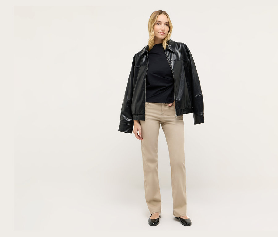 Eine blonde Frau steht und trägt eine schwarze Jacke und Angels Denim »Lara« Straight Fit Jeans.