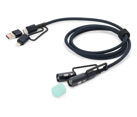 Ein blaues Ladekabel mit USB-, USB-C- und Lightning-Anschlüssen sowie zwei kleinen LED-Leuchten und einem Silikonaufsatz liegt auf einem weißen Hintergrund.