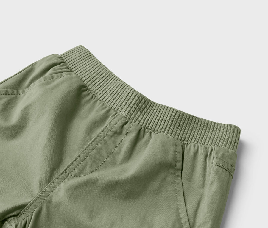 Nahaufnahme einer olivgrünen Hose mit elastischem Bund und Taschen.