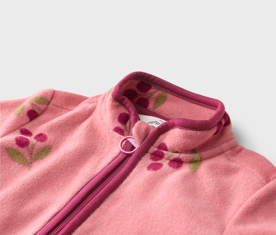 Nahaufnahme einer rosa Fleecejacke mit Reißverschluss und Blumenmuster.