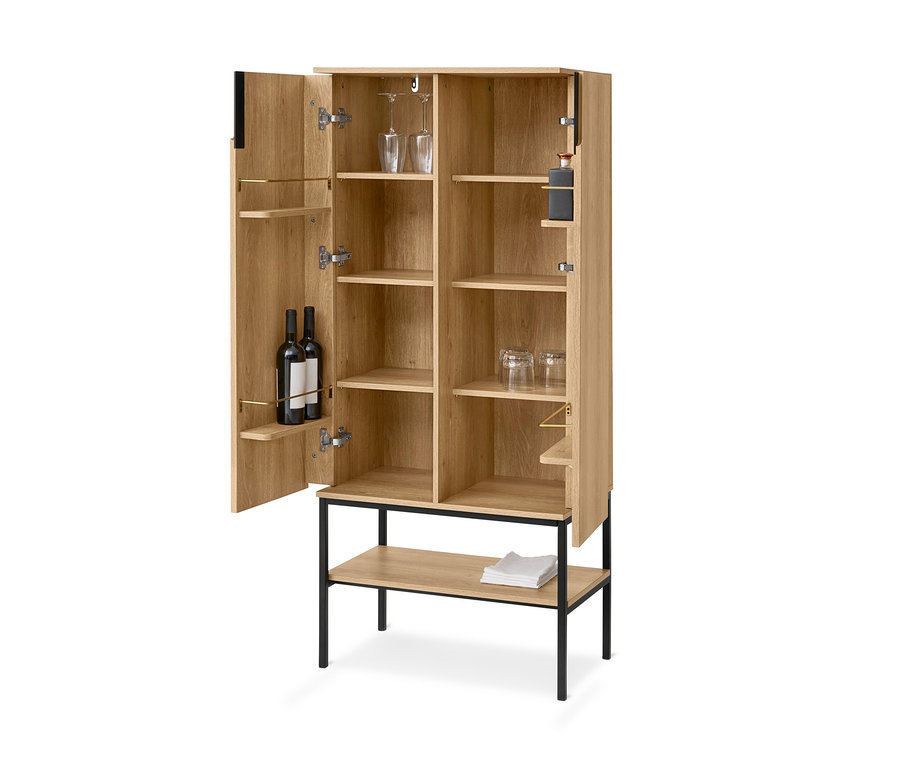 Heller Holz-Barschrank mit offenen Türen, gefüllt mit Weinflaschen, Weingläsern und anderen Gläsern. Er steht auf schwarzen Metallbeinen und hat ein offenes unteres Regal mit weißen Servietten.