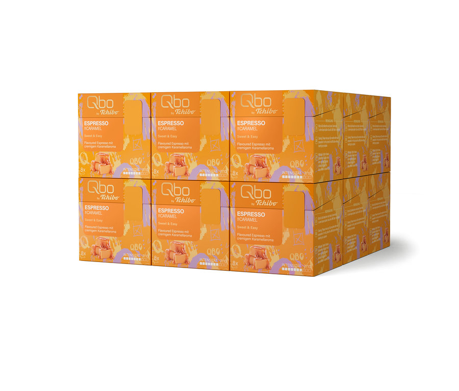 Sechs orangefarbene Qbo by Tchibo Espresso Caramel-Packungen sind in zwei Stapeln angeordnet.