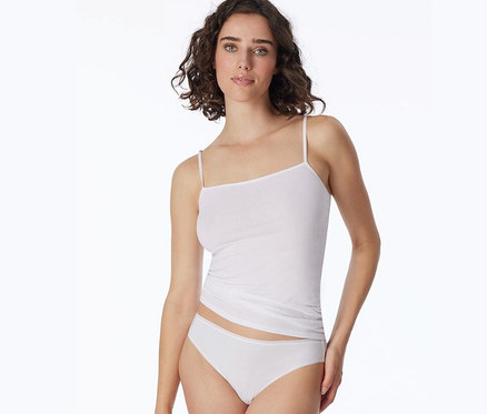 Frau trägt weißen Top und 2 SCHIESSER Minislips mit Bio-Baumwolle, weiß.