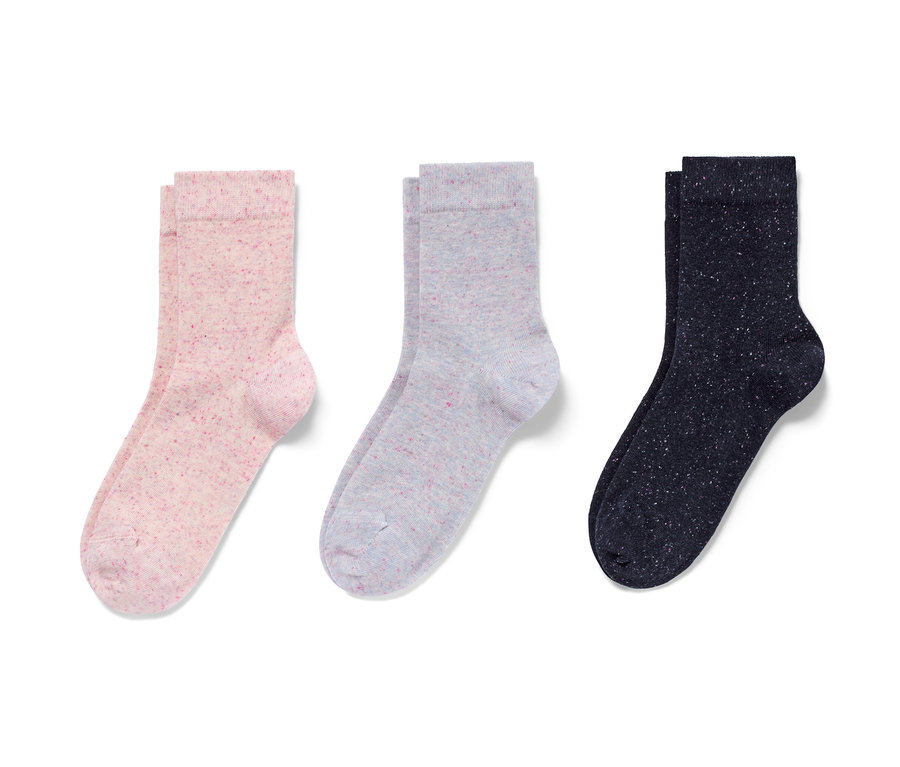 Drei Paar Socken mit Effektgarn liegen auf einem weißen Hintergrund.
