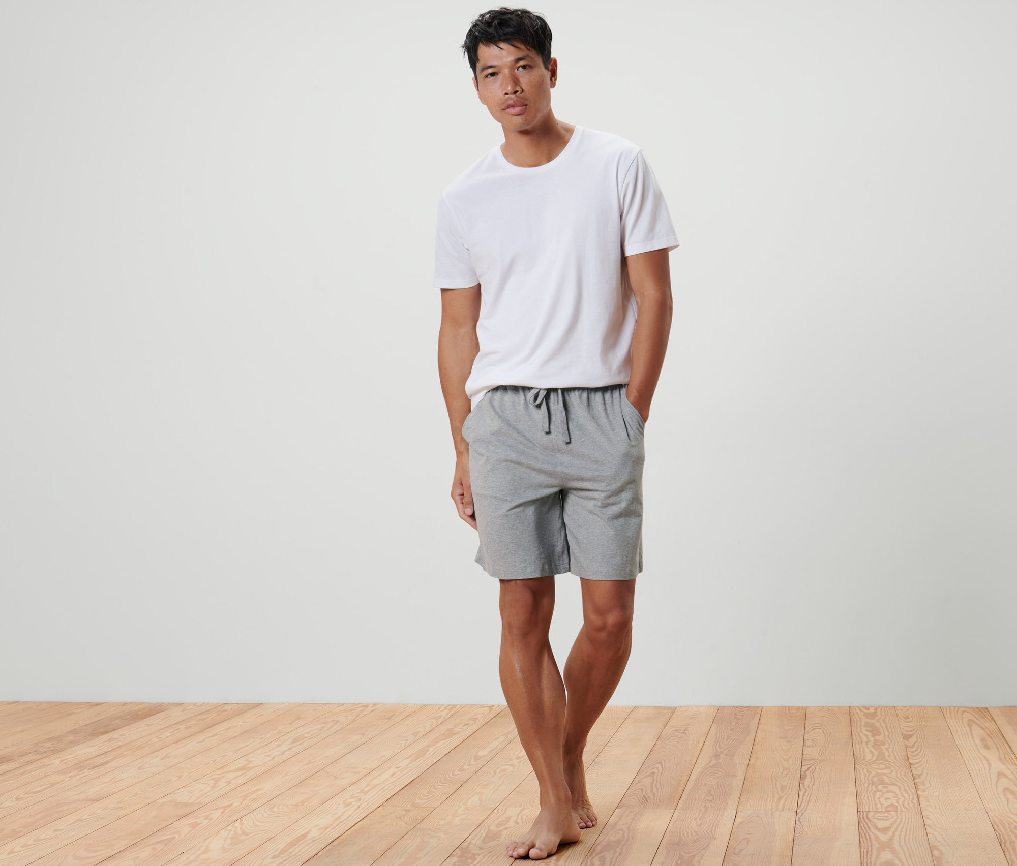 Mann steht mit Händen in den Taschen der Kurzen Relaxhose.