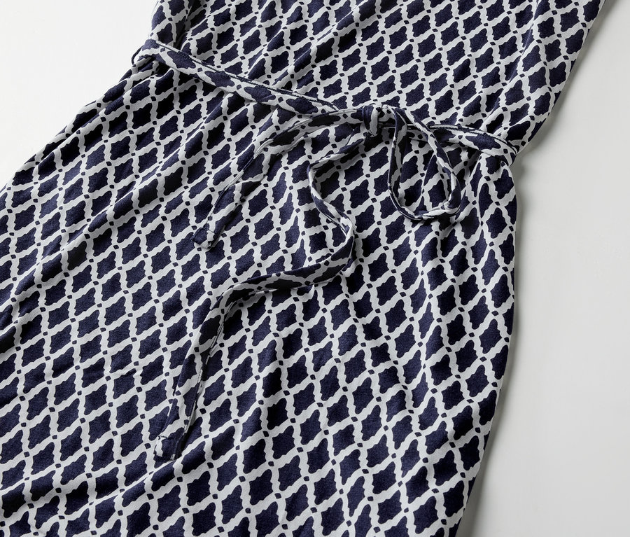 Detailansicht eines bedruckten Jerseykleids mit Bindegürtel.