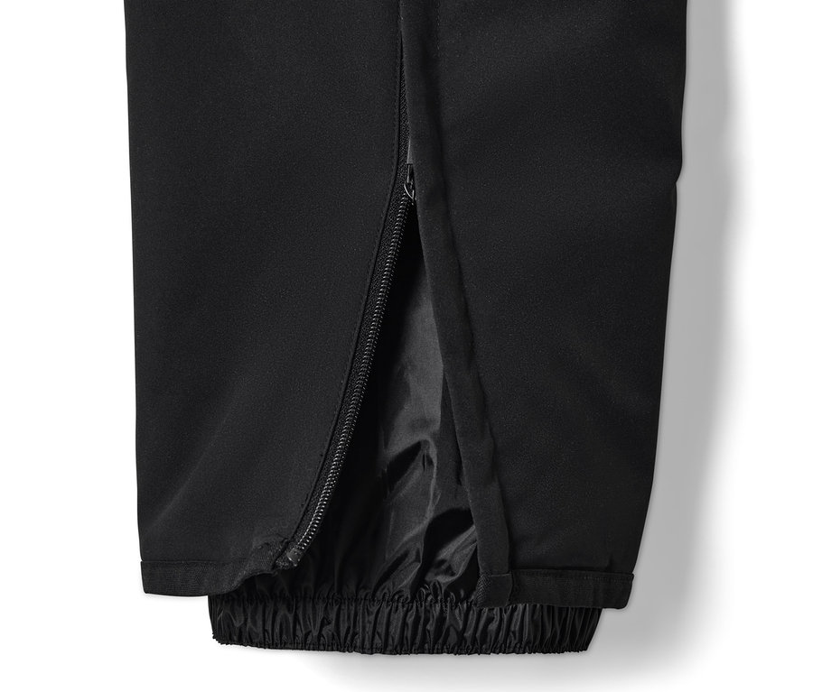 Detail einer schwarzen High-Tech-Skihose mit Reißverschluss am Bein.