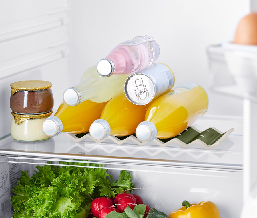 Im Kühlschrank sind Marmeladen, Getränke in einem Kühlschrank-Flaschenhalter, Gemüse und Eier.