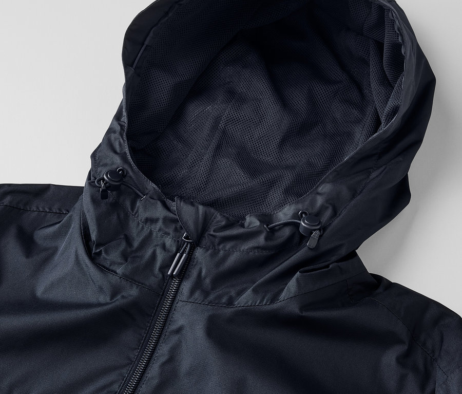Detailaufnahme einer schwarzen Unisex-Regenjacke mit Kapuze und Reißverschluss.
