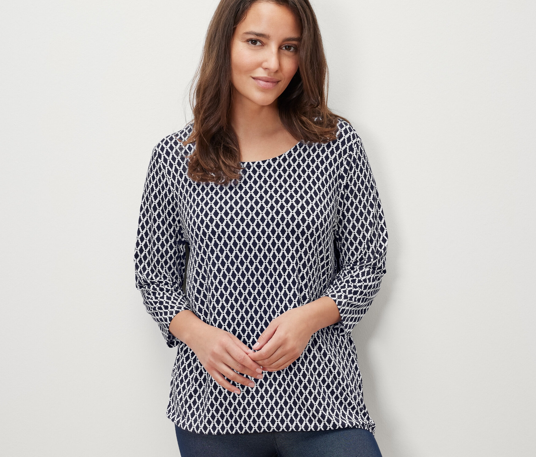 Frau trägt ein bedrucktes Blusenshirt.