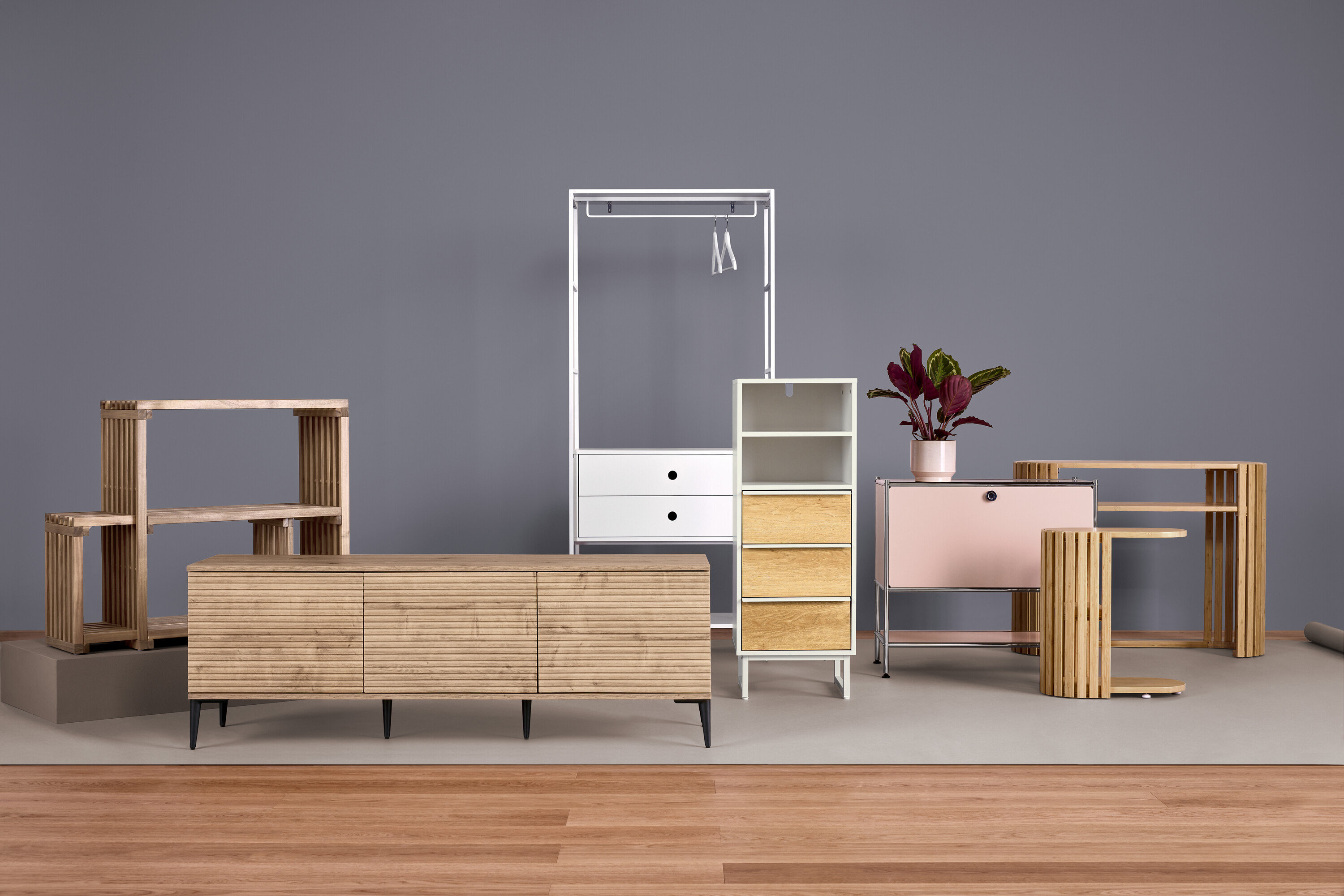 Möbel in verschiedenen Stilen vor grauem Hintergrund.