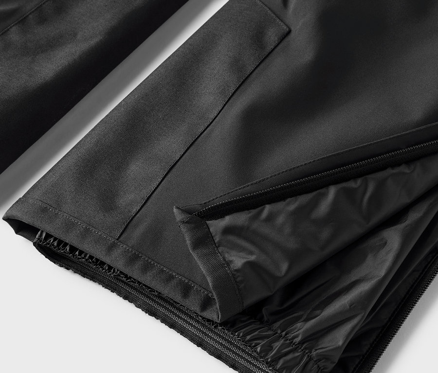 Detail einer schwarzen Hose mit geöffnetem Reißverschluss.