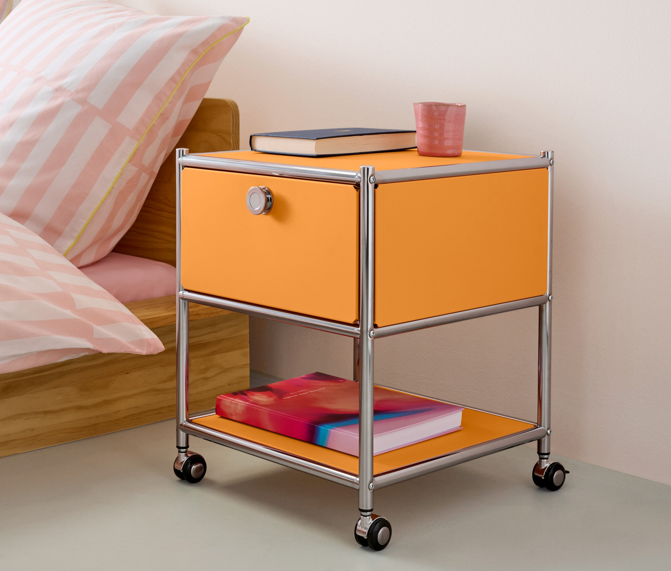 Orangefarbener Beistelltisch mit Schublade Metall »CN3« steht neben einem Bett.
