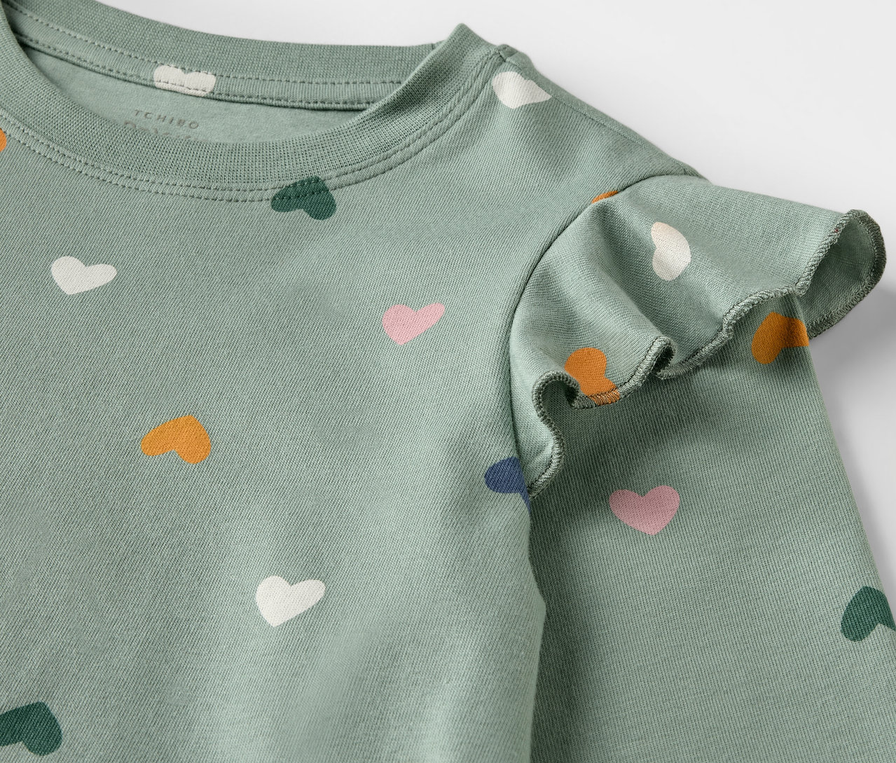 Detailansicht eines Kinder-Nachthemds mit Herzchenmuster.