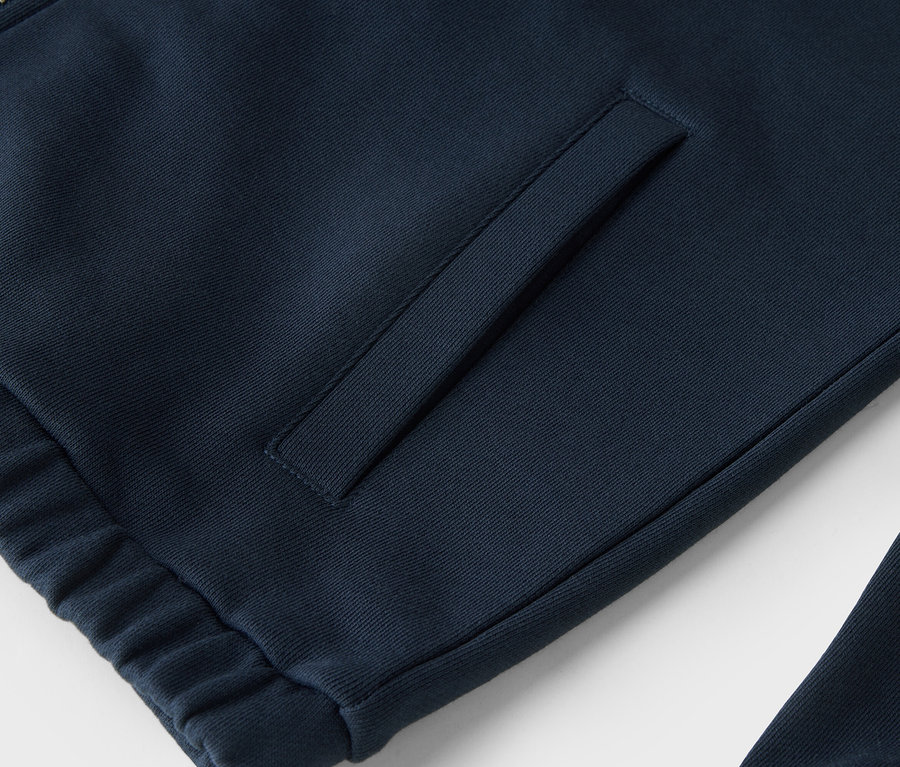 Detailaufnahme einer marineblauen Sweatshirtjacke mit Reißverschluss und Tasche.