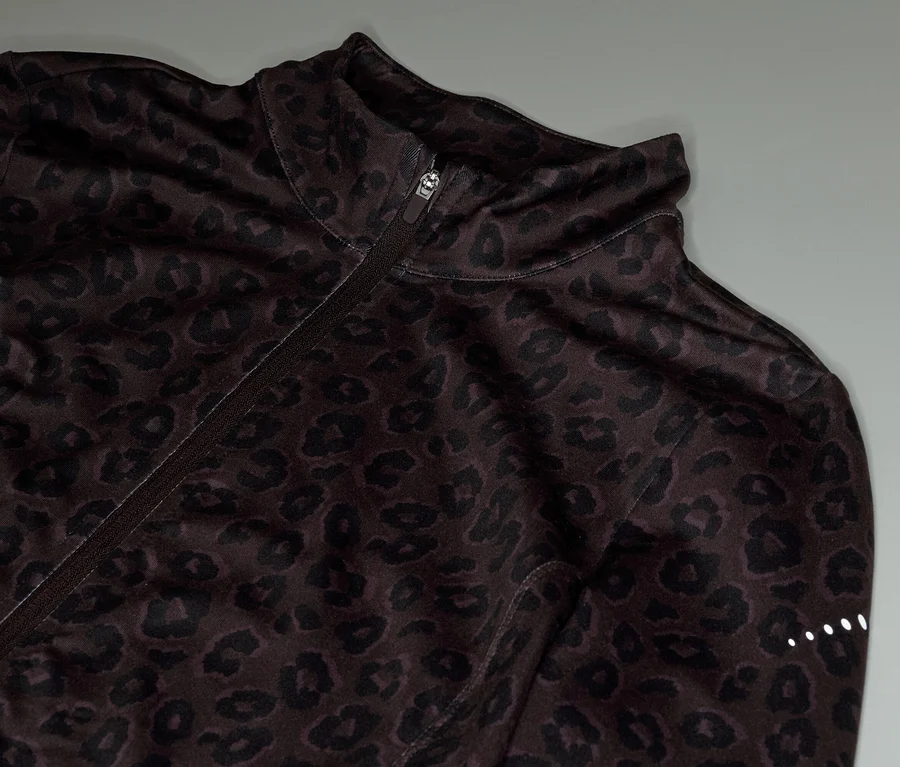 Nahaufnahme einer braunen Trainingsjacke mit Leopardenmuster und Reißverschluss.