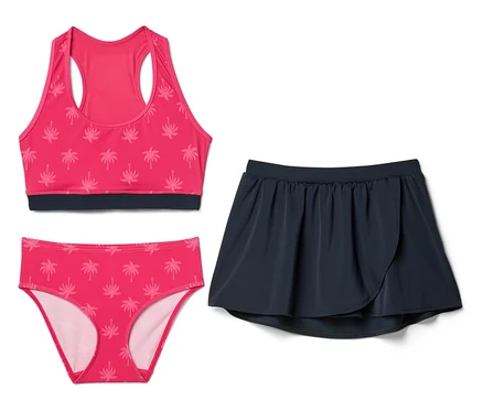 Pinkes Badeoberteil und Bikinihose mit Palmenmuster neben einem marineblauen Rock.