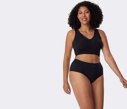 Frau trägt einen schwarzen BH und Slip.