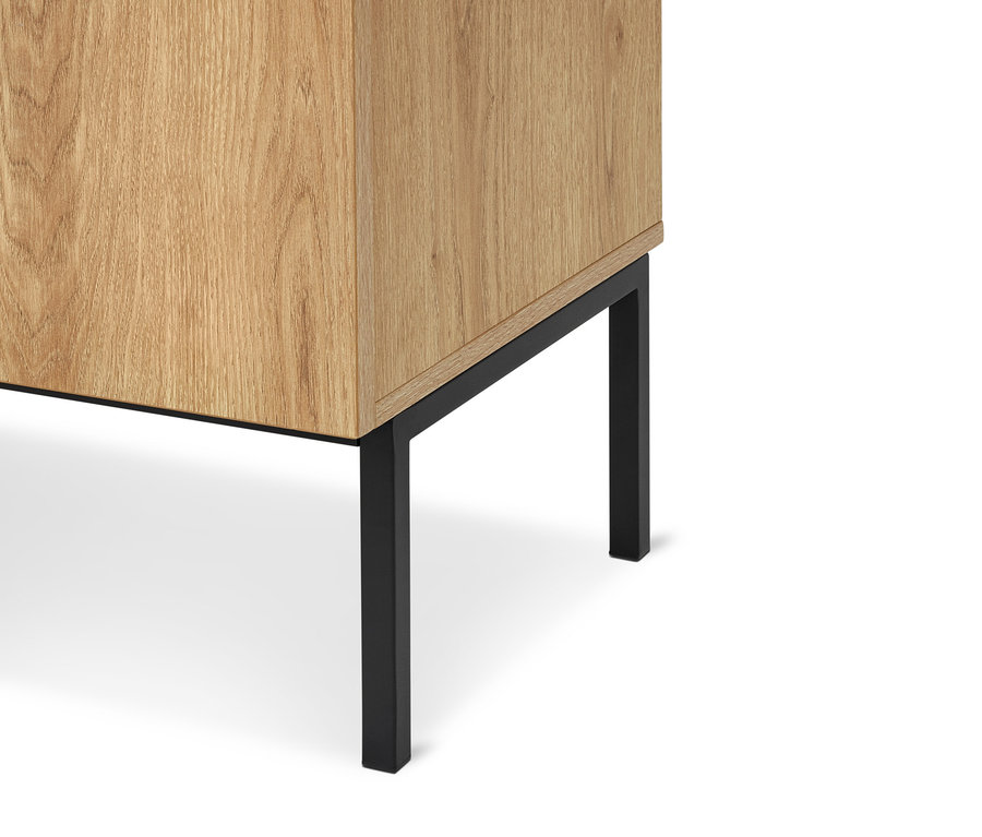 Unterer Eckbereich eines hellen Schranks mit Holzmaserung und zwei schwarzen Metallbeinen.