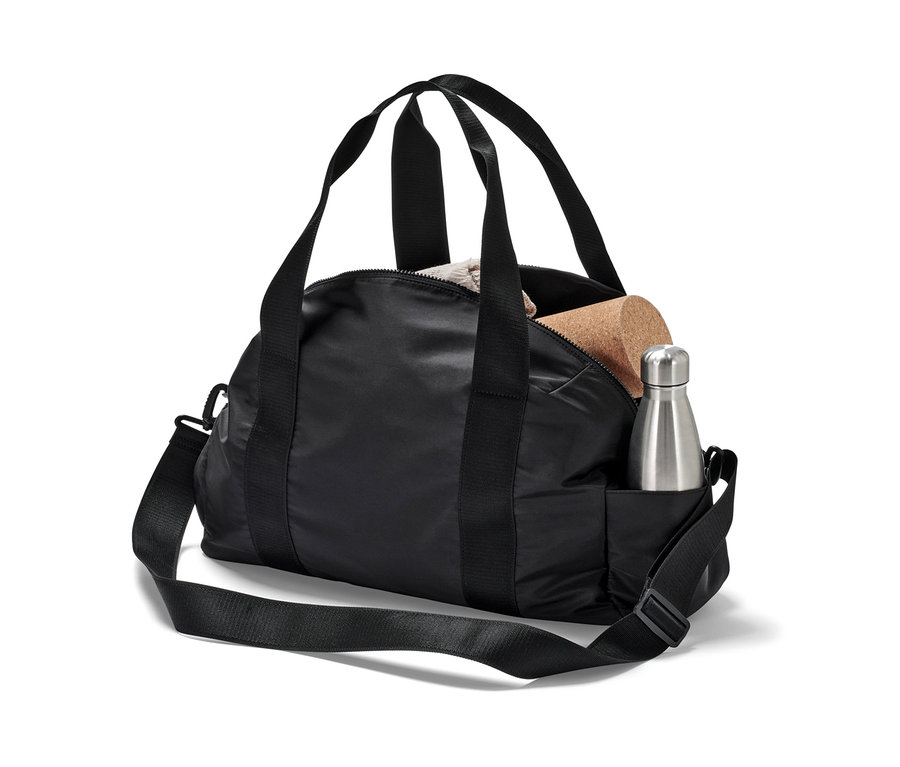 Eine schwarze Sporttasche mit einer silbernen Wasserflasche und einem Korkblock.