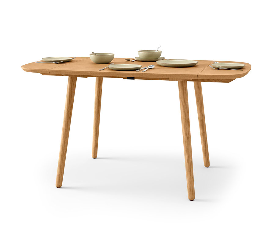 Gedeckter Holzesstisch mit Tellern und Schüsseln.