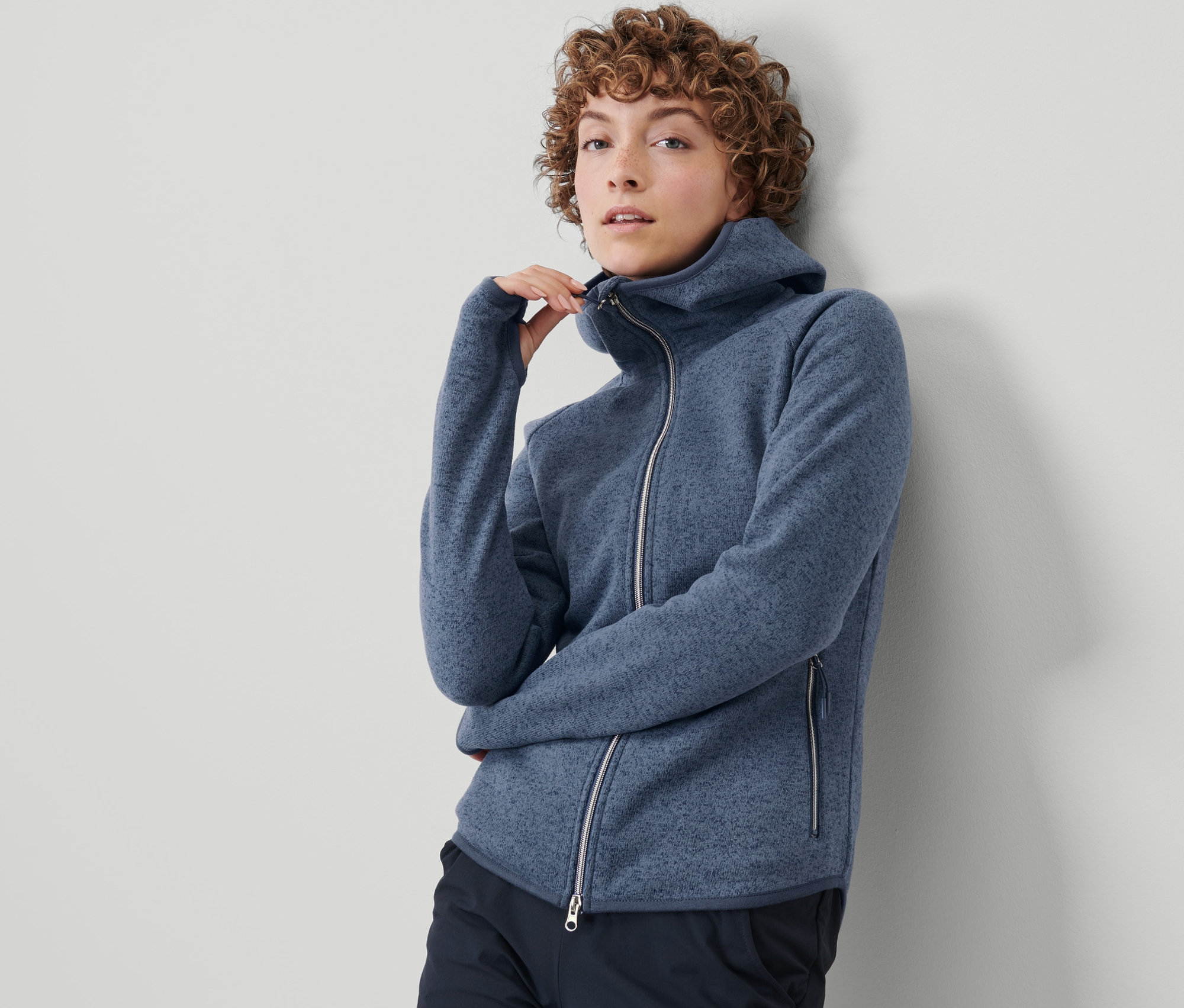 Frau schliesst ihre Strickfleece-Jacke.