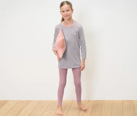 Mädchen hält rosa Kissen und trägt 2 Kinder-Pyjamas.