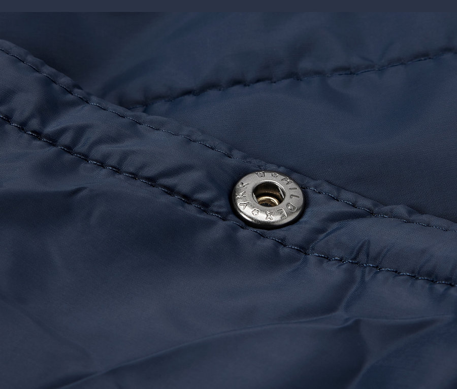 Detailansicht einer dunkelblauen, ultraleichten Reisedecke mit Druckknopf.