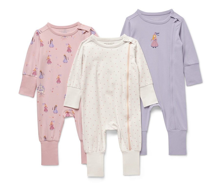 Drei Baby-Pyjamas mit Prinzessin-Motiv. Ein rosa Pyjama mit Prinzessinnen-Print, ein weißer mit rosa Punkten und ein lila Pyjama mit Prinzessin.