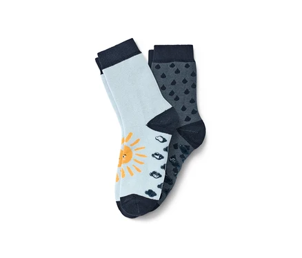 Zwei Paar blaue Kleinkind-Antirutsch-Socken. Ein Paar hellblau mit gelber Sonne, das andere dunkelblau mit Regenmotiv.