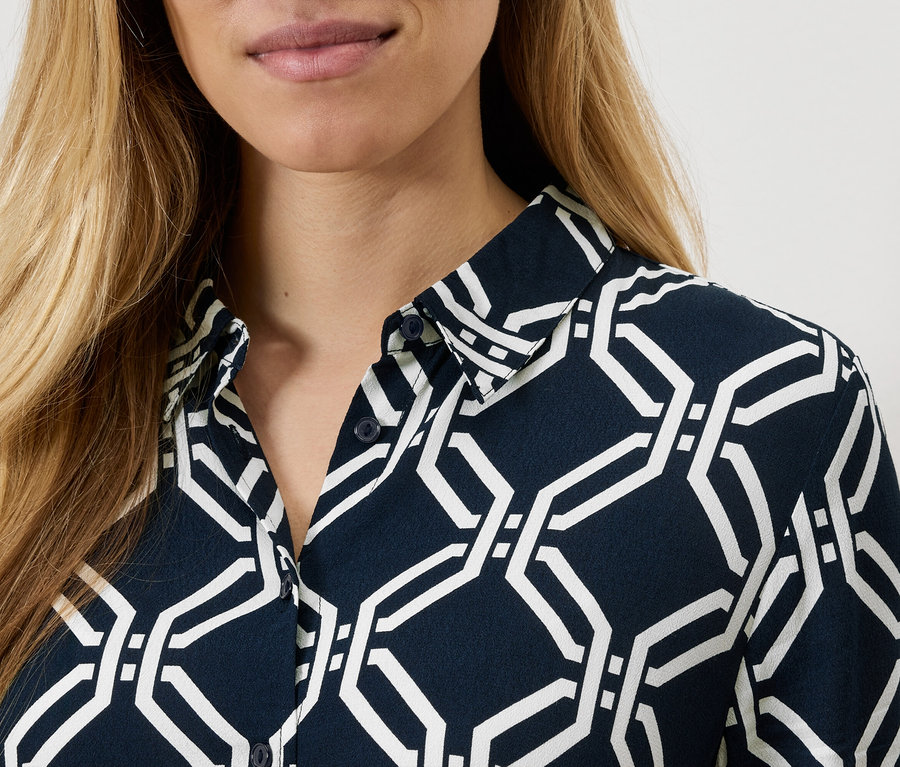 Detailaufnahme einer Damenbluse mit geometrischem Muster.