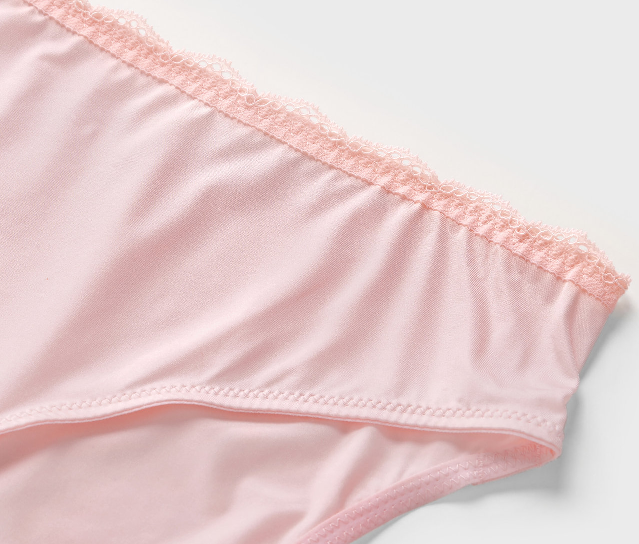 Detailansicht von 2 rosafarbenen Slips mit Spitze.