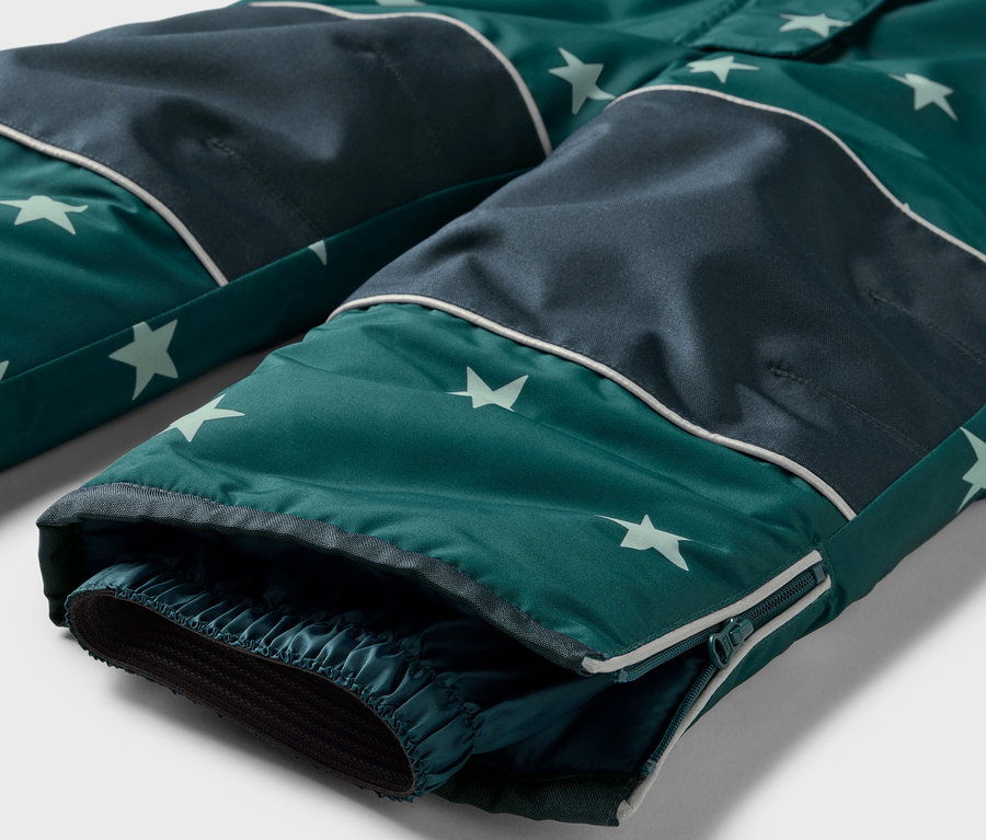 Detail einer grünen Hose mit Sternmuster und dunkelblauen Knien.