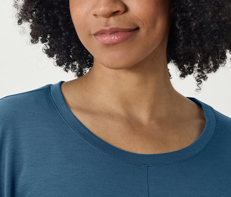 Detailaufnahme vom Gesicht und dem blauen T-Shirt einer Frau.