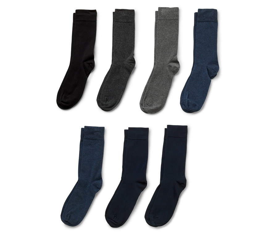 Sieben Socken in Schwarz, Dunkelgrau, Grau und Blau liegen auf einem weißen Hintergrund.