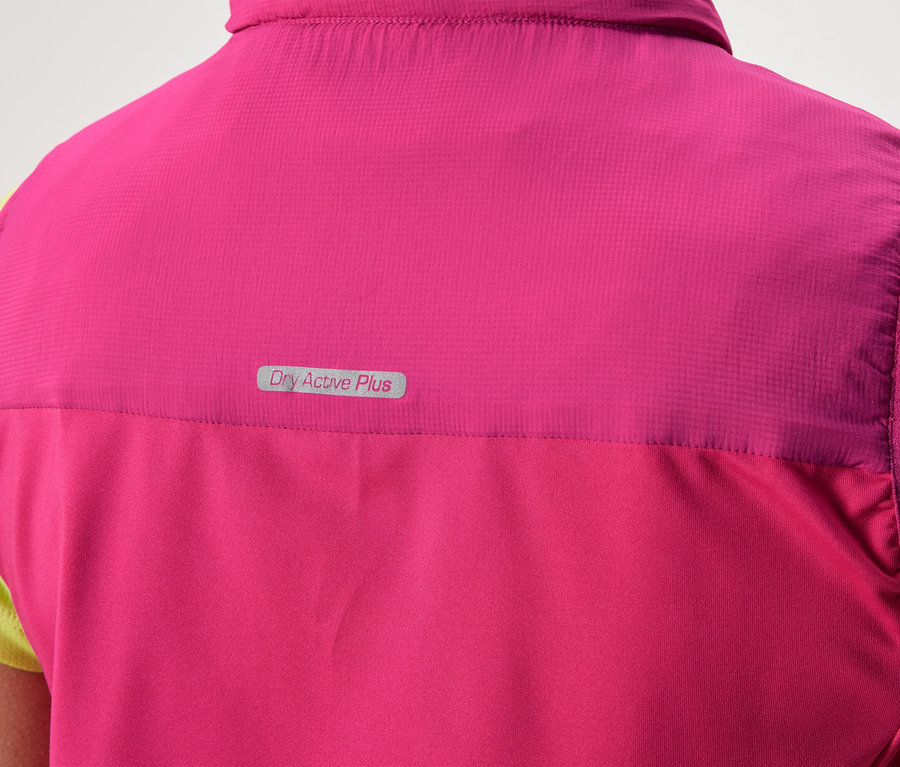 Rückansicht einer Person, die eine pinke Weste mit der Aufschrift "Dry Active Plus" über einem hellgrünen Shirt trägt.